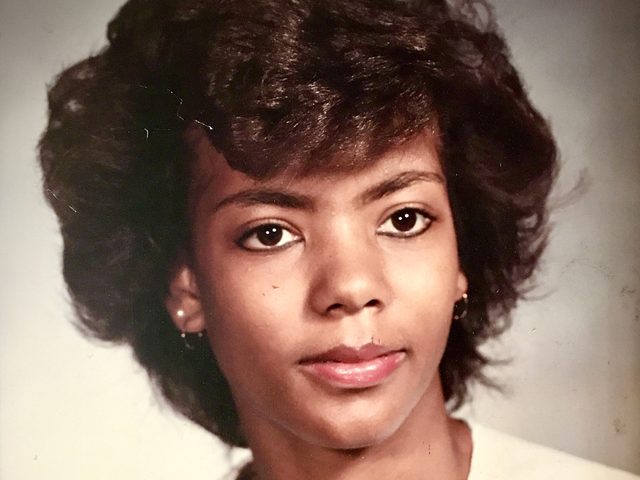 Angela's 1985 high school graduation portrait, holding a rose